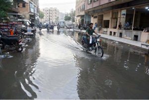 A motorcyclist wades through stagnant sewerage water at Pan Mandi area