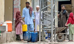 Residents of Tarlai area fetching drinking water from a nearby Naan shop due to insufficient supply of water in the area