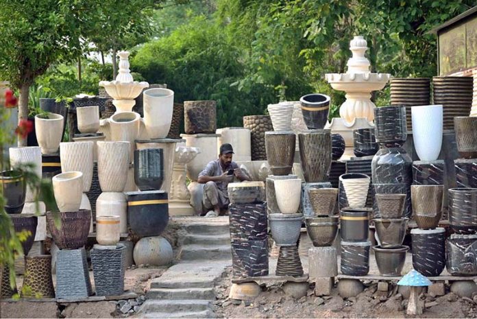 A vendor waits for customers to sell plant pots at Rawal Dam Chowk in the Federal Capital