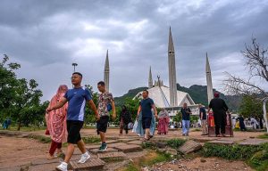 Visitors stroll near the iconic Faisal Masjid in Federal Capital under a cloudy monsoon sky, enjoying the serene atmosphere and scenic backdrop of the Margalla Hills.