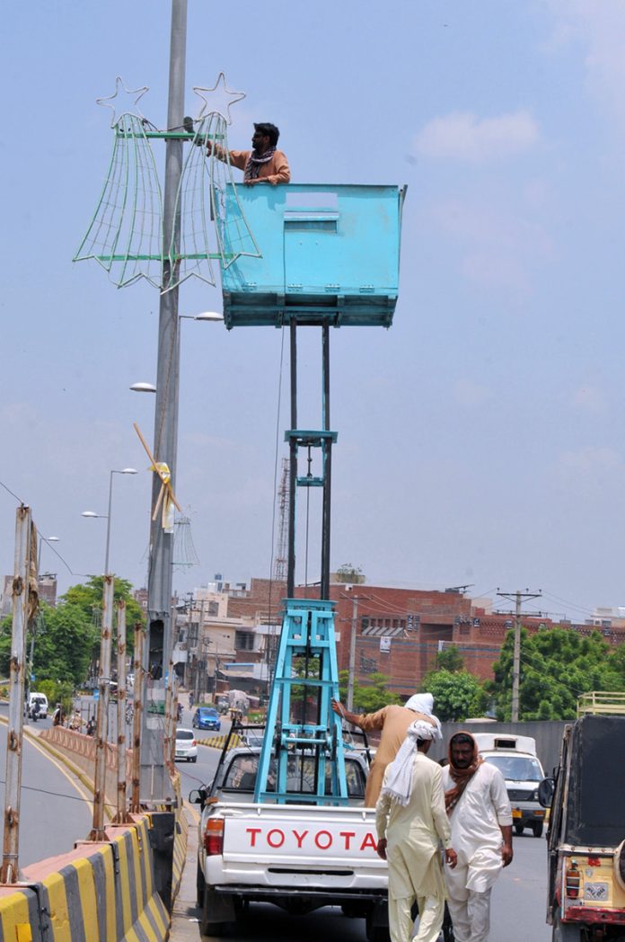 Staffers of Municipal Corporation busy in maintenance work of an electric pole to ensure uninterrupted power supply in the area