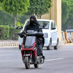 A woman rides a scooty on the way to her destination in the City