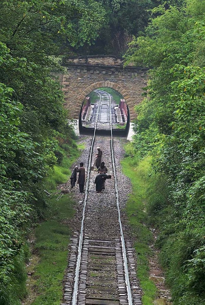 Railway workers carry out repair work on the track near Korang Tunnel — a historic 50-meter-long structure built in 1914 by British engineers. Located adjacent to the Korang Bridge, which spans the Korang River originating from the Murree Hills, the tunnel is part of the active Karachi–Peshawar Railway Line (ML-1)