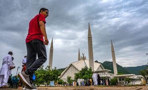 Visitors stroll near the iconic Faisal Masjid in Federal Capital under a cloudy monsoon sky, enjoying the serene atmosphere and scenic backdrop of the Margalla Hills.