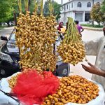 A vendor displaying dates to attract customers at roadside