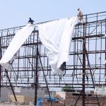 Workers install an advertising banner on a billboard at Chungi No. 09