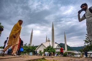 Visitors stroll near the iconic Faisal Masjid in Federal Capital under a cloudy monsoon sky, enjoying the serene atmosphere and scenic backdrop of the Margalla Hills.