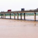 Vehicles are passing over the bridge in the Bypass area as the water level of the Indus River has risen due to recent monsoon rains in the country.