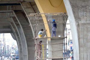 A labourer busy paint the plant pots at 6th Road overhead bridge