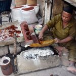 A hardworking craftsman prepares furniture polish using traditional methods at his workplace