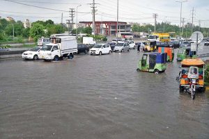 Vehicles pass through rainwater accumulated on IJP Road after heavy rainfall in the city.