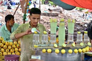 A vendor selling traditional summer drink at his roadside setup during hot and humid weather in Federal Capital