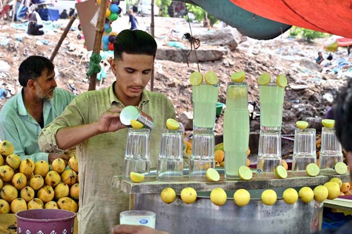 A vendor selling traditional summer drink at his roadside setup during hot and humid weather in Federal Capital