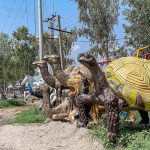 A vendor displays replicas of different animals at a roadside to catch the attention of customers