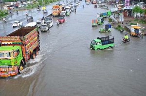 Vehicles pass through rainwater accumulated on IJP Road after heavy rainfall in the city.