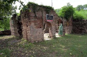 A woman explores the ruins of an ancient mosque situated at the premises of Lotus Lake in the capital. The centuries old abandoned structure was discovered during the development work of the lake in year 2020 in the area, once known as Parian village. The Bunyan tree grown adjacent to the mosque is believed to be some 500 years old.