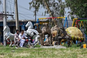 A vendor displays replicas of different animals at a roadside to catch the attention of customers