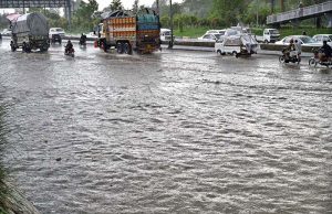 Vehicles pass through rainwater accumulated on IJP Road after heavy rainfall in the city.