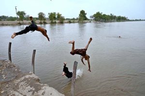 Youngsters beat the heat by diving and swimming in Dadu Canal, seeking relief from the sweltering summer in the city