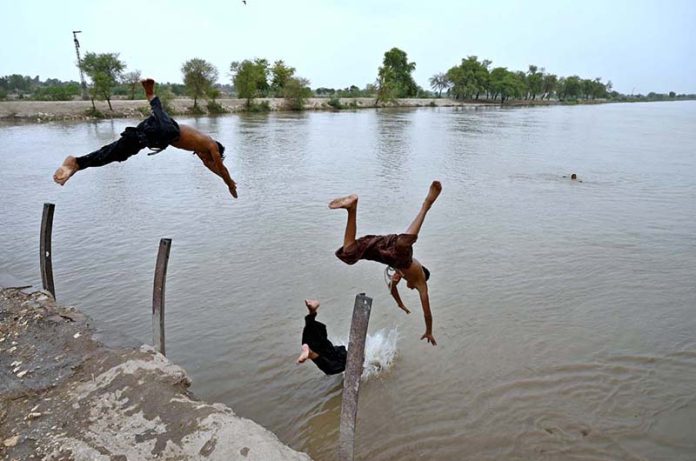Youngsters beat the heat by diving and swimming in Dadu Canal, seeking relief from the sweltering summer in the city