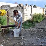 A person fill pot after fetching water from a well in Golra, the Federal Capital