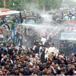 Volunteers uses cannons to spray water on mourners to get relief from the heat during the 10th Ashura procession to commemorate the death anniversary of Hazrat Imam Hussein, the grandson of prophet Muhammad (PBUH) and his companion, who were martyred in the battle of Karbala, Iraq