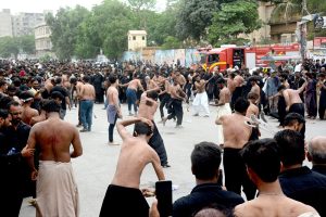 Volunteers uses cannons to spray water on mourners to get relief from the heat during the 10th Ashura procession to commemorate the death anniversary of Hazrat Imam Hussein, the grandson of prophet Muhammad (PBUH) and his companion, who were martyred in the battle of Karbala, Iraq