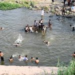 Youngsters enjoy bathing in Korang Nallah near Chak Shahzad to find relief from hot weather in the Federal Capital
