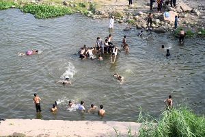 Youngsters enjoy bathing in Korang Nallah near Chak Shahzad to find relief from hot weather in the Federal Capital