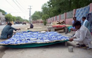 Workers are busy preparing traditional curtain (Chik) at their roadside setup.