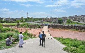 A large crowd has gathered along the Korang Nullah at Sharifabad in the Federal Capital as water levels rose following recent rains. Security personnel are preventing people from crossing the bridge after a young man drowned in the nullah