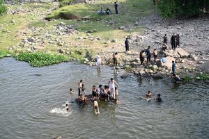 Youngsters enjoy bathing in Korang Nallah near Chak Shahzad to find relief from hot weather in the Federal Capital