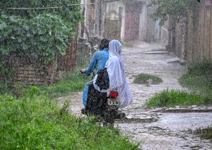 Boys enjoy play in the street during heavy Monsoon rain in the city.