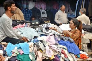 Women busy selecting and purchasing cutlery and utensils from a roadside stall