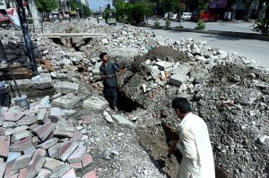 Laborers busy digging along a road for the installation of sewerage lines in the Commercial Market area.