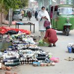 A woman purchasing tea cups from the roadside vendor