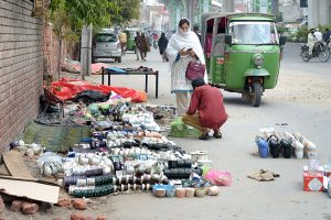 A woman purchasing tea cups from the roadside vendor