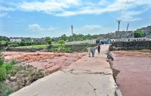 A large crowd has gathered along the Korang Nullah at Sharifabad in the Federal Capital as water levels rose following recent rains. Security personnel are preventing people from crossing the bridge after a young man drowned in the nullah