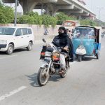 A Woman riding motorcycle on the way towards her destination in the City
