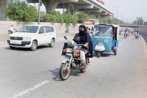 A Woman riding motorcycle on the way towards her destination in the City