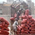 Labourers off-loading potato-filled sacks from trucks at vegetable market for onward distribution to local vendors in the city