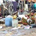 Gypsy women busy in washing the cloth outside their temporary hut near Railway Station area