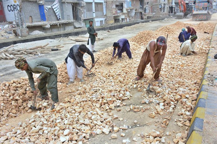 Labourers busy in construction work of new Auto Bahn Road during development work in the city
