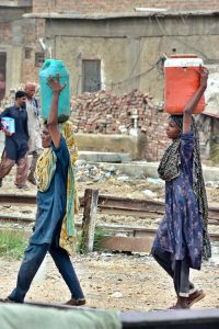 Gypsy women busy in washing the cloth outside their temporary hut near Railway Station area