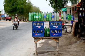 A vendor displaying the petrol in the plastic bottles at Larkana-Ratodero Road
