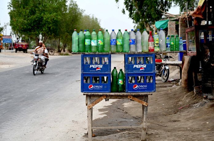 A vendor displaying the petrol in the plastic bottles at Larkana-Ratodero Road