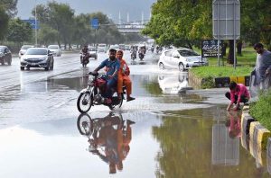 Vehicles navigate through stagnant rainwater following heavy rainfall in the Federal Capital