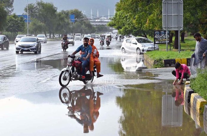 Vehicles navigate through stagnant rainwater following heavy rainfall in the Federal Capital