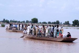 People load motorcycles and other equipment onto boats to cross the Sutlej River in the Nawahi area. AP