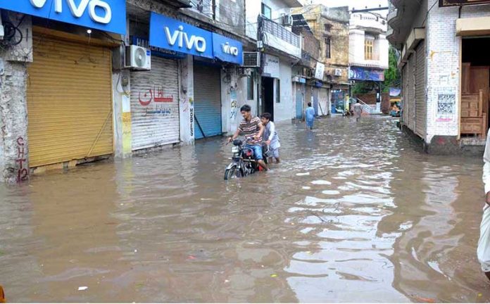 A heavy downpour measuring 97 millimetres disrupts daily life in the city, as roads are inundated with rainwater during the second spell of the monsoon at Tehsil Road Furniture Market in Chiniot